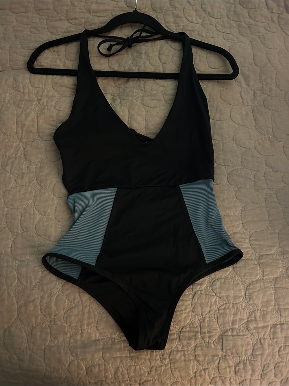 Woman’s soft cheeky black one-piece swimsuit, tie back with slate blue accents